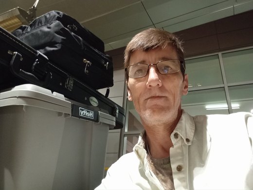 Sig beside travel bags at an airport.